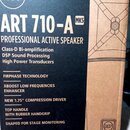 Fotografie zachycuje část kartonového obalu od reproduktoru. Na tmavě modrém pozadí je bílý nápis RCF v kruhu, model ART 710-A MK5 a text PROFESSIONA…
