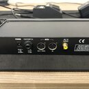 Zadní strana černého elektronického zařízení s několika konektory. Jsou zde nápisy POWER, FOOTSWITCH, MIDI (s výstupy OUT / THRU a IN), 44.1K S/PDIF…