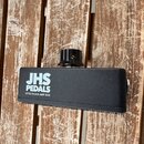Černý efektový pedál s nápisy JHS PEDALS a LITTLE BLACK AMP BOX. Na horní straně je umístěn černý otočný knoflík s viditelným šroubem. Zařízení má ma…