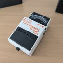 Bílý kytarový ladič s černým gumovým pedálem a ovládacími prvky. Na horní části je nápis Chromatic Tuner TU-3, OUTPUT, BYPASS a INPUT. V horní části…