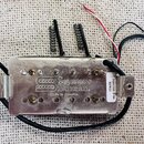 Kovový snímač s nápisy Seymour Duncan. a Made in America. Na boku je nalepený bílý štítek s označením I04JG shr-4 20110520. Z přístroje vedou černé,…