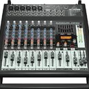 Černý mixážní pult s bílými popisky a řadou posuvníků. Na horním panelu jsou nápisy behringer, KLARK TEKNIK a EUROPOWER PMP500. V pravé části je červ…