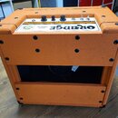 Kytarový kombo zesilovač v oranžovém texturovaném potahu s černými plastovými rohy. Na horním bílém panelu je nápis ORANGE a model TINY TERROR, dále…