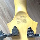 Detail zadní strany hlavy kytary zC světlého dřeva. Je zde černý nápis „Crafted in Indonesia“ a sériové číslo „W121051816“, vedle kterého je logo CE…