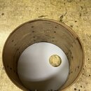 Dřevěný korpus bubnu v hnědé barvě bez natežené kožečky. Vnitřní strana korpusu obsahuje kovové šrouby a úchytky pro napínací mechanismus. Spodní str…