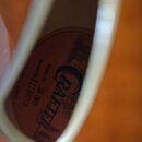 Detailní pohled do dutiny akustické kytary s viditelnou vnitřní štítkem. Na štítku je velký nápis CRAFTER a texty Model No. SA-TMVS, Serial No. 11100…