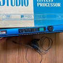 Modrý rackový efektový procesor s černými bočními panely a nápisem Digitech Studio v bílém rámečku. V pravé části je umístěn černý ovládací knoflík,…