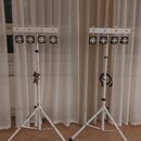 Dvě bílé světelné lišty s LED moduly umístěné na bílých teleskopických stativech. Na horní části každé lišty je nápis "estelle". Každá lišta obsahuje…