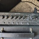 Horní ovládací panel kytarového komba s černým povrchem a stříbrným lemováním. Na panelu jsou nápisy INPUT, VOICE, GAIN, VOLUME, EQUALISATION, EFFECT…
