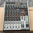 Stříbrno-černý mixážní pult značky behringer. Na horním panelu je nápis USB a v pravém horním rohu logo behringer. Zařízení obsahuje několik vstupníc…