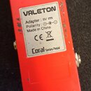 Zadní strana červeného efekt pedálu značky VALETON. Na stříbrném štítku je uveden nápis Adapter : 9V, Polarity : (symbol polarity), Made in China, zn…
