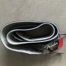 Svijený kytarový popruh z tmavě modré kůže s šedým vnitřním povrchem. Na přiloženém červenobílém štítku je nápis Fender a text Strap GUITAR AND BASS.…