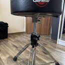 Černý polstrovaný bubeníckýstolek s kovovým chromovaným stativem a nastavitelní výškou. Na sedadle je vidět červeno-bílé logo s nápisem Gibraltar. Po…