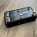 Černý kontrolér s kovovým horním panelem a šesti stříbrnými spínači. Na panelu je bílý nápis Spark a menší text CONTROL X. Jsou zde rovněž označení I…