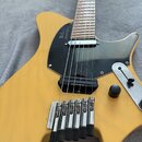Žlutá elektrická kytara s černým pickguardem a hnedým hmatníkem. Na pickguardu je nápis "Strandberg" a na snímači text "Seymour Duncan". Kobylka nese…