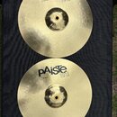 Dvě mosazné činely typu hi-hat v žlutozlaté barvě s jemným žebrováním. Oba mají nápis pAiste 101 BRASS, přičemž horní činel nese doplňující text 14"…