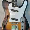 Polodupatá elektrická kytara s barevným přechodem od žluté k černé. Má bílý pickguard, dva snímače typu single-coil a chromovaný most s integrovaným…