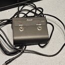 Černý nožní spínač z plastu nebo kovu s logem Marshall. Na horní straně jsou dvě stříbrná tlačítka s nápisy BOOST a FX LOOP, nad kterými jsou umístěn…
