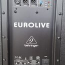 Zadní panel černého reproduktoru s nápisem EUROLIVE a logem behringer. Horní část obsahuje konektory INPUT A, THRU A, OUTPUT A, INPUT B, THRU B a OUT…
