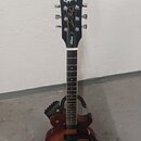 Elektrická kytara v tmavě hnědé barvě s přechodem do světlejšího odstínu uprostřed korpusu. Na hlavě hmatníku je bílý nápis Epiphone a zlaté nápisy L…