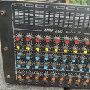 Černý desetkanálový mixážní pult s nápisem MRP 300 model III a popiskem 10 CHANNEL POWER MIXER WITH DIGITAL DELAY AND EQUALIZER. Zařízení obsahuje řa…
