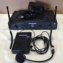 Černý bezdrátový systém značky SAMSON. Sestává z přijímače s nápisem SAMSON a Wireless Receiver, vysílače s nápisem SAMSON a označením CB20 a hlavníh…