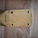 Detail dřevěné hlavy kytary v přirozené barvě. Na povrchu je svislý nápis MADE IN JAPAN a vpravo nápis STD-62. Jsou vidět čtyři otvory po ladících st…