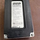Zadní strana efekt pedálu v černém obalu s kovovým rámem. Uprostřed je bílý štítek s nápisy DOD ELECTRONICS CORPORATION, Salt Lake City, Utah, USA a…