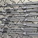 Sada sedmi stříbrnošedých rozkládacích stativů z kovu s černými gumovými úchyty a koncovkami. Na trubicích je u každého kusu viditelný nápis KONIG &…