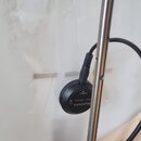 Detailní záběr na bílý povrch nástroje s připevněným černým kruhovým snímačem. Na snímači je bílý nápis SUNNYN, Mini Pickup a OUTPUT. Snímač je připo…