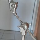Detailní pohled na chromovaný kovový stojan s nápisem TAMA. Stojan obsahuje nastavitelné klouby s utahovacími šrouby a na horním konci je nasazena še…