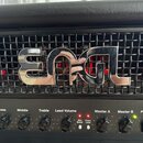 Detailní pohled na přední panel kytarového komba v černé barvě s koženým potahem. Na černé mřížce je umístěno výrazné chromované logo ENGL. Pod ním s…