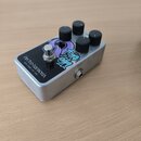 Stříbrný efektový pedál s nápisem electro-harmonix NEW YORK CITY, USA. Na horní ploše je fialový grafický motiv s nápisy FILTER a INPUT. Zařízení má…