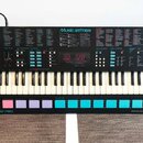 Černý digitální klavír s bílými a černými klávesami. Na horním panelu je nápis MUSIC STATION, digitální displej zobrazující hodnotu 120 a řada ovláda…