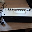 Kytarový kombozesilovač s krémovým horním panelem a černým spodním tělem. Na přední straně je nápis YAMAHA THR30II Wireless a kovová rukojeť. Horní p…