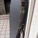 Černý tvrdý kufýr na hudební nástroj s kovými hranami a vrchovery. Povrch je matně černý, v horní části je vidět kovový zámek. Na kufýru nejsou žádné…