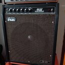 Černý kytarový kombo zesilovač s hnědou textilní maskou. Na ovládacím panelu jsou nápisy CREATIVE SOUND ® EVANS MUSICAL AMPLIFIER a popisky ovladačů…