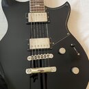Černá elektrická kytara s tmavým hmatníkem a chromovaným hardwarem. Nástroj má dva humbuckery s kovovými kryty, dva oválné ovládací knofíky a jeden p…
