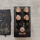 Černý kytarový efekt pedál s nápisy v měděné barvě. Na horní části jsou čtyři kovové otočné knoflíky s popisky GAIN, VOL, BASS a TREBLE. Uprostřed je…