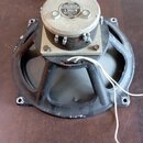 Černý reproduktor s kovovým rámem a magnetem. Na horní části magnetu je kovový štitek s nápisy VEB KOMBINAT STEREO-RADIO BERLIN, ELEKTROAKUSTIK LEIPZ…
