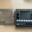 Černý sampler s nápisem blackbox a logem 1010music. Zařízení má uprostřed displej, několik ovládacích knoflíků a řadu bílých tlačítek s popisky PADS,…