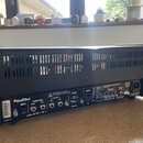 Zadní strana černého kytarového komba. Na zadním panelu jsou nápisy „Hughes & Kettner“, „MIDI IN“, „FOOTSWITCHES Channels / Effects“, „FX LOOP Send /…