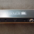 Záběr na spodní stranu černého efektového pedálu s kovovým zlatým rámem. Na štítku je nápis Guitar/Bass Intelligent Pedal, loga FC, CE, RoHS a text M…