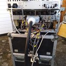 Stojan s rackovými zařízeními v černém transportním kufru s hliníkovým profilem. Horní jednotka nese nápisy BEHRINGER MODEL EDD296 a BEHRINGER ADAT-1…