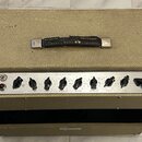Kytarový kombo zesilovač s béžovým potahem z textilie a kovovými rohy. Na předním ovládacím panelu jsou nápisy EQUALIZATION, MASTER, VOLUME a označen…