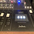Detailní pohled na černý míchací pult s bílými popisky a ovládacími prvky. Na panelu jsou nápisy HERITAGE EDITION, MIX PROCESSING s přepínači XFRMR D…