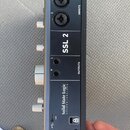 Černý audio rozhraní s nápisy SSL 2 a Solid State Logic OXFORD-ENGLAND. Zařízení má dva vstupy označené jako INPUTS (1 a 2), dva výstupy OUTPUTS (L a…