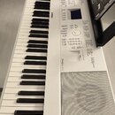 Bílá digitální klaviatura s černými a bílými klávesami. Na ovládacím panelu jsou viditelné nápisy Roland a modelové označení RD-64. Přístroj obsahuje…