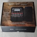 Kartonová krabice s produktem Zoom A1X FOUR Acoustic Multi-Effects Processor With Expression Pedal. Na krabici je zobrazen černý efektový procesor s…