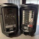 Dva černé plastové aktivní reproduktory z pohledu zadního panelu. Levý reproduktor má schéma zapojení a nápisy STAGEPAS 400i, PORTABLE PA SYSTEM a lo…